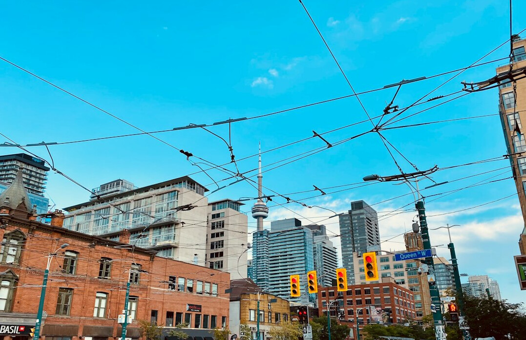 Canadian city skyline at golden hour with streetcar lines in foreground